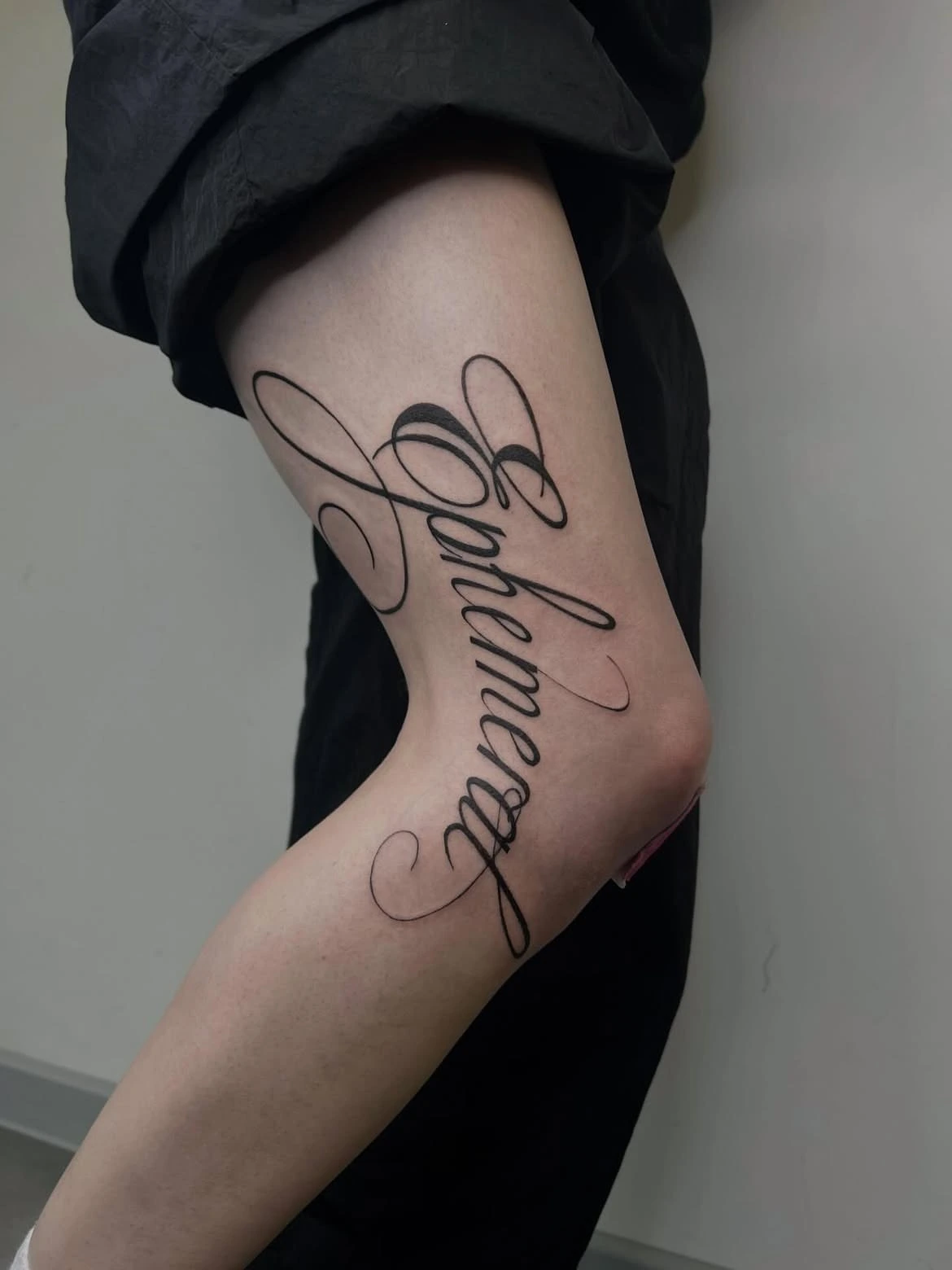 Inscription calligraphique Ephemeral sur le bras